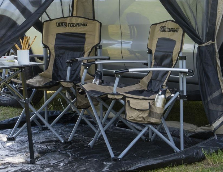 ARB* Silla de camping con bolsa con correa de hombro negra y beige.